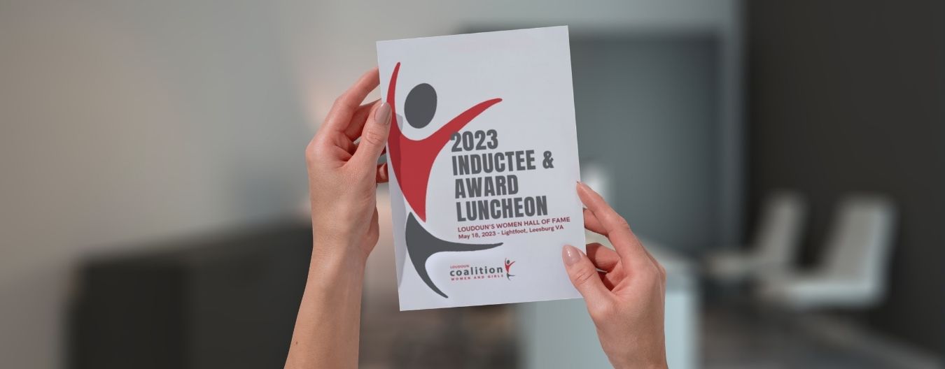 Hands holding a program booklet for the 2023 Inductee & Award Luncheon for Loudoun’s Women Hall of Fame.